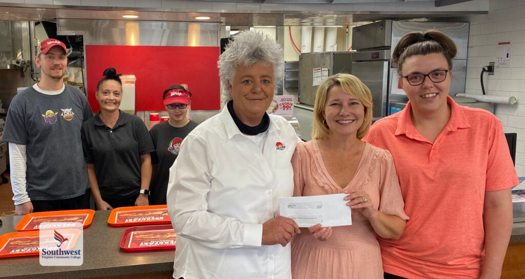 Cherie Fields prenets donation check to Susan Lowe for Great Expectations program.