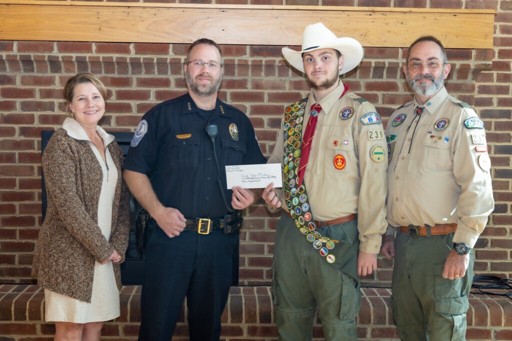 Bryce Stinson presenting check to chief Justin McCulley, with Susan Lowe and Jerry Stinson present as well.