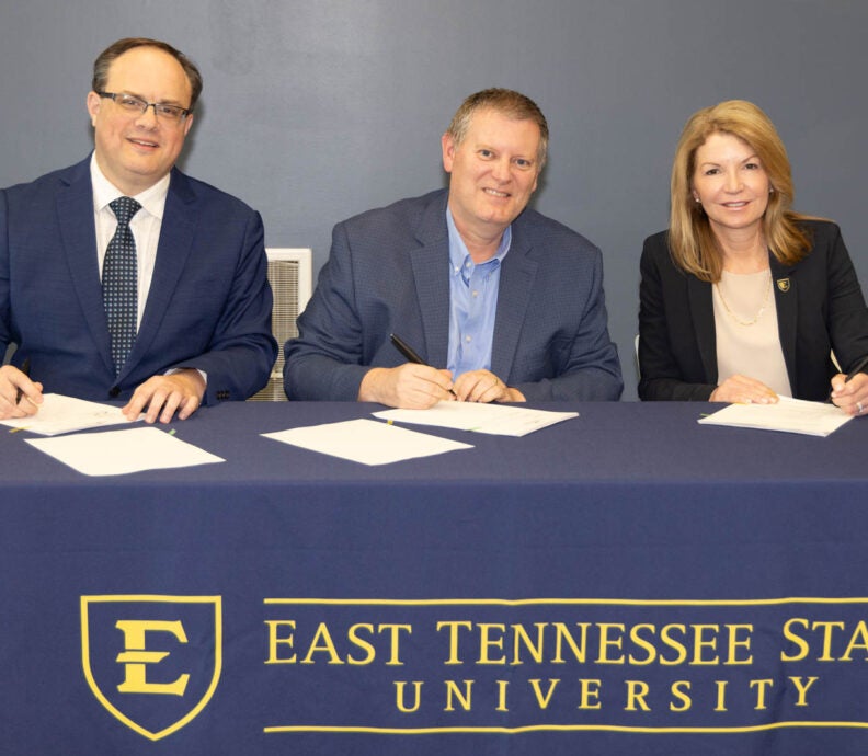 signing paperwork between ETSU and SWCC
