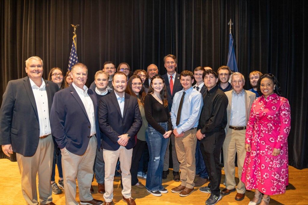 Before the event, a group of students and college board members met backstage with Gov. Youngkin, Sen. Hackworth, and Del. Morefield for a photo. (L-R, front) Sen. Travis Hackworth, Dr. Tommy Wright, Del. Will Morefield (Center-back), Gov. Glenn Youngkin, and (far right front) A.J. Robinson, Virginia Community College System board member) take a photo with a group of Southwest students and local college board members.