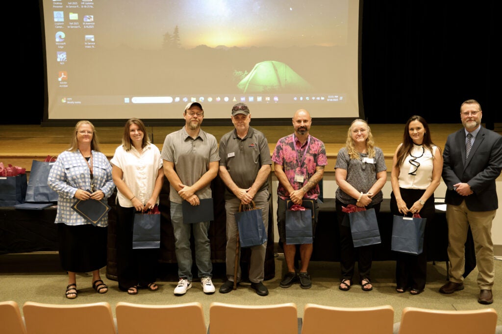 a group of faculty and staff being recognized for their five years of service next to Dr. Hayes
