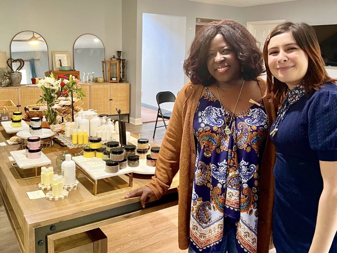 Kanika Wallace and Delaney Goodman standing in front of a table of skincare products.