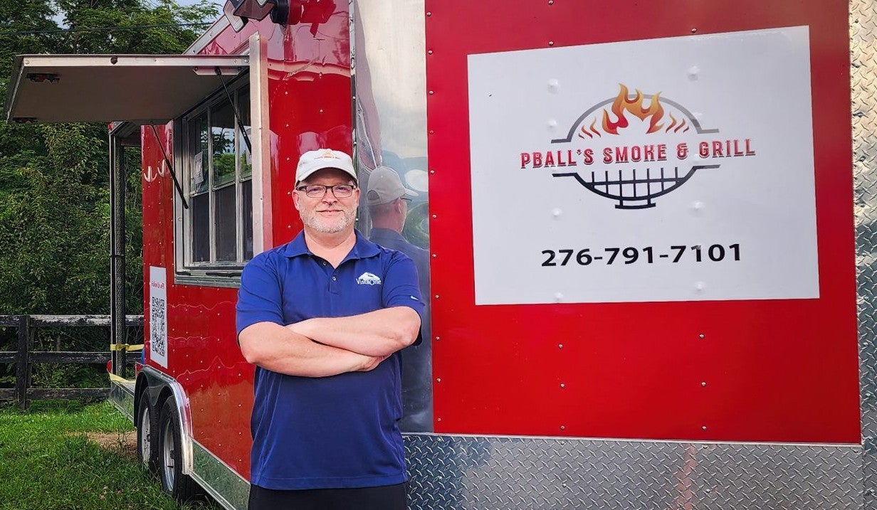 Preston Ball Standing next to his PBall's Smoke and Grill food truck