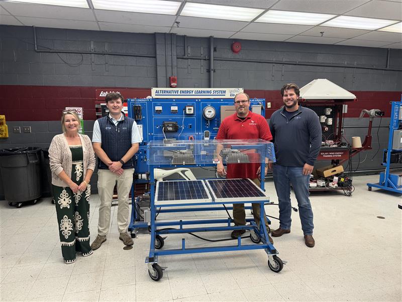 CEP Solar photo. four people posing alongside a solar panel