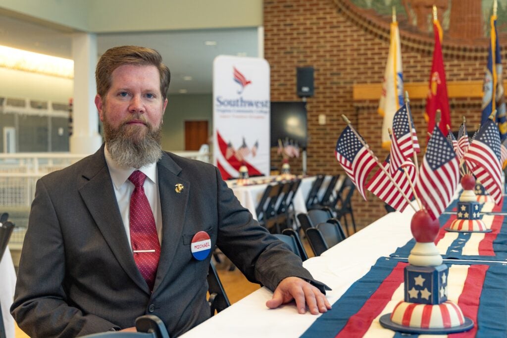 Michael Herndon sitting at a table with a bunch of US Flags