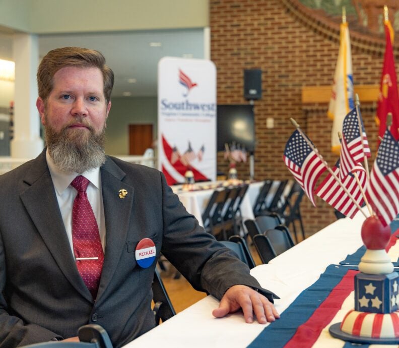 Michael Herndon sitting at a table with a bunch of US Flags