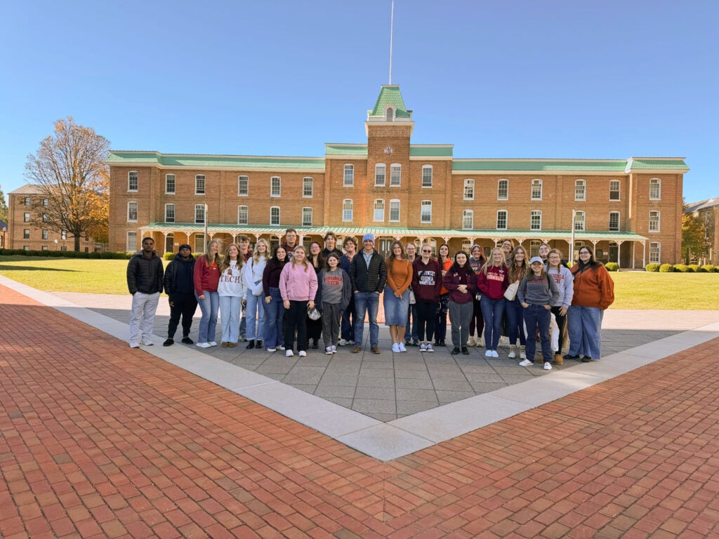 A group photo of the Honors Group standing in front of a building on a Brick pathway