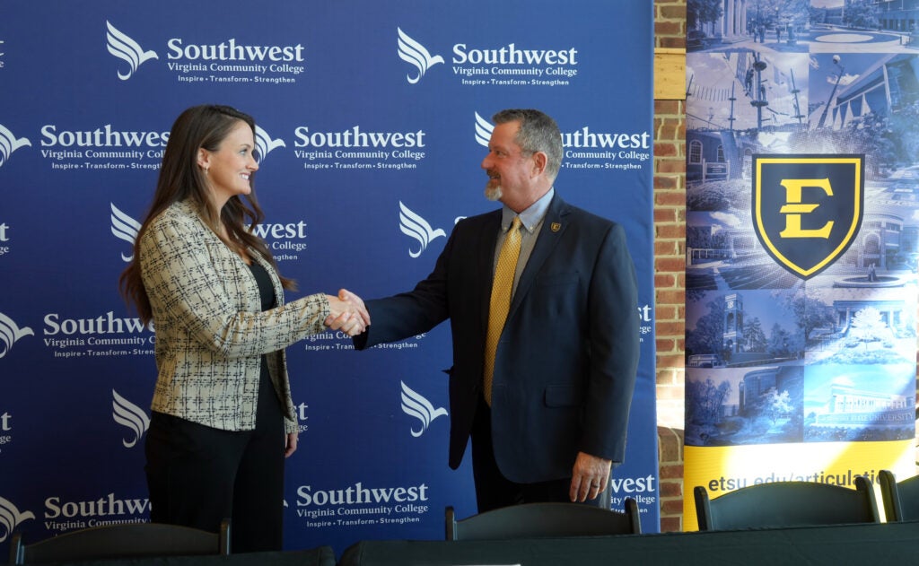 Dr. Bethany Rose shaking hands with Dr. Bill Flora