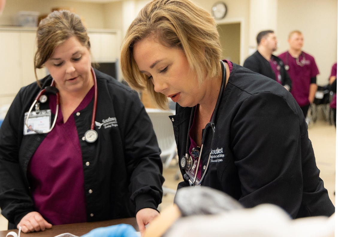 Two female nursing students work in the nursing simulation lab