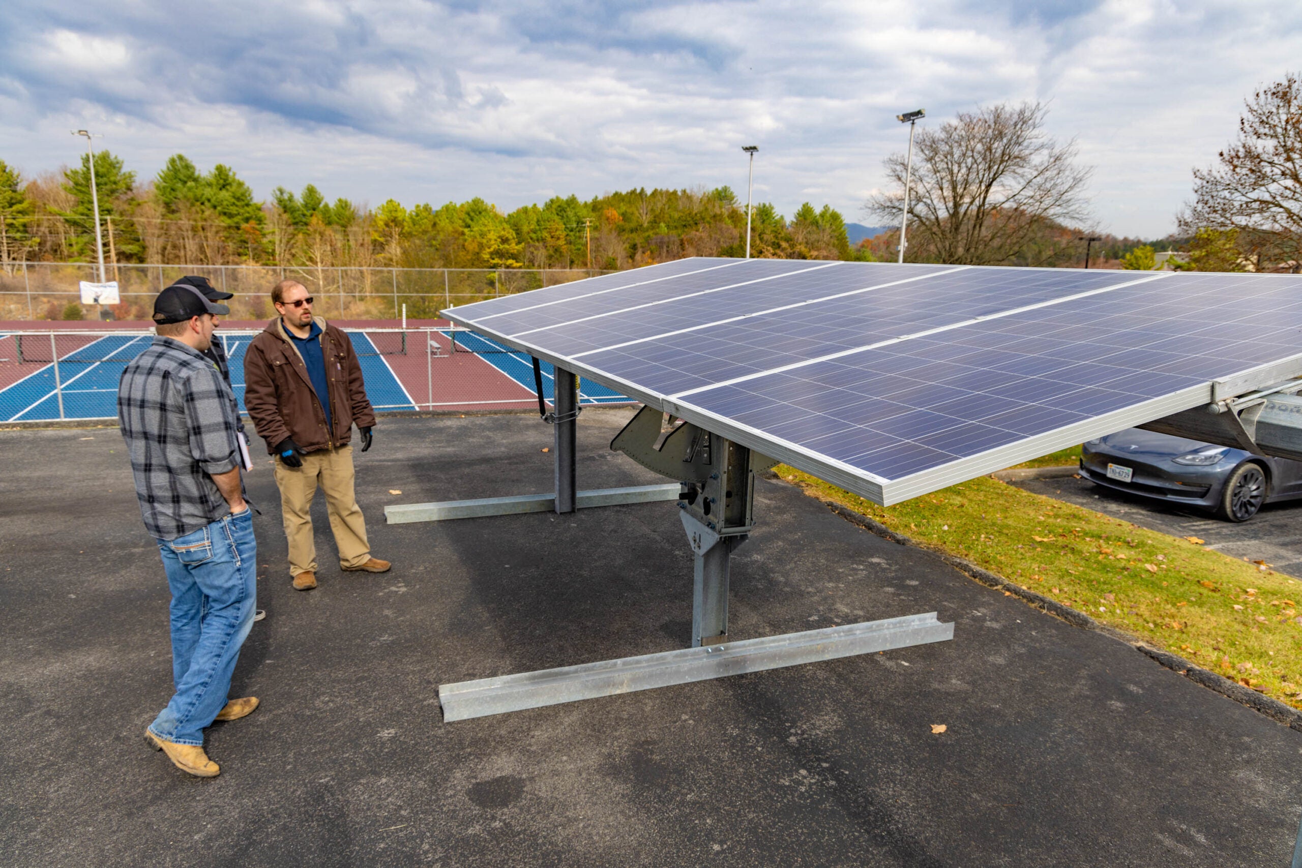 Faculty and students look at portable solar trainer.