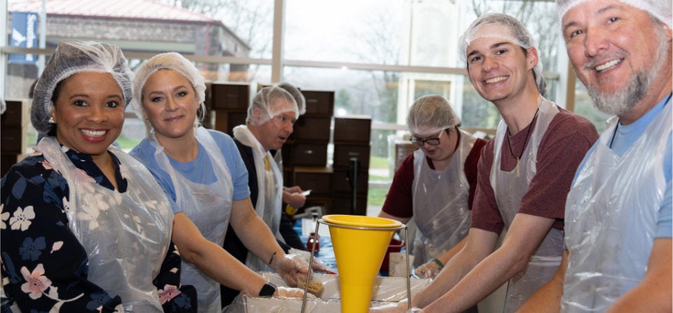 Students, Employees, and Community Members packing food for the Day of Service